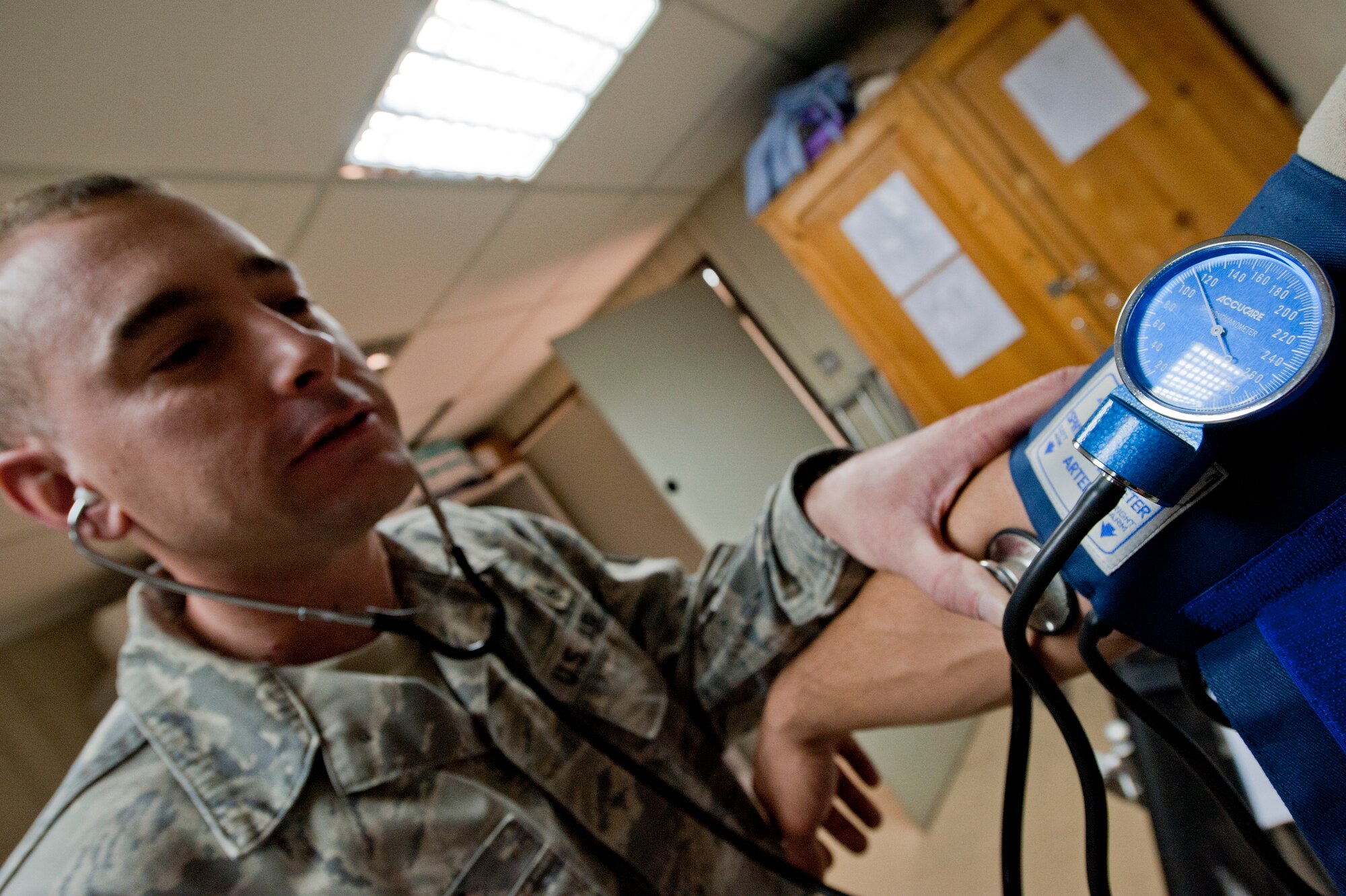 Tech. Sgt. Brian Schmit, 332nd Expeditionary Medical Group medical technician, checks the blood pressure of a patient in an undisclosed location in Southwest Asia, Jan 19, 2012. Schmit uses a stethoscope to listen to the flow of blood during the exam.  Schmit is deployed from Spangdahlem Air Base, Germany, and is a native of Rogers Ark. (U.S. Air Force photo by Staff Sgt. Joshua J. Garcia/Released)