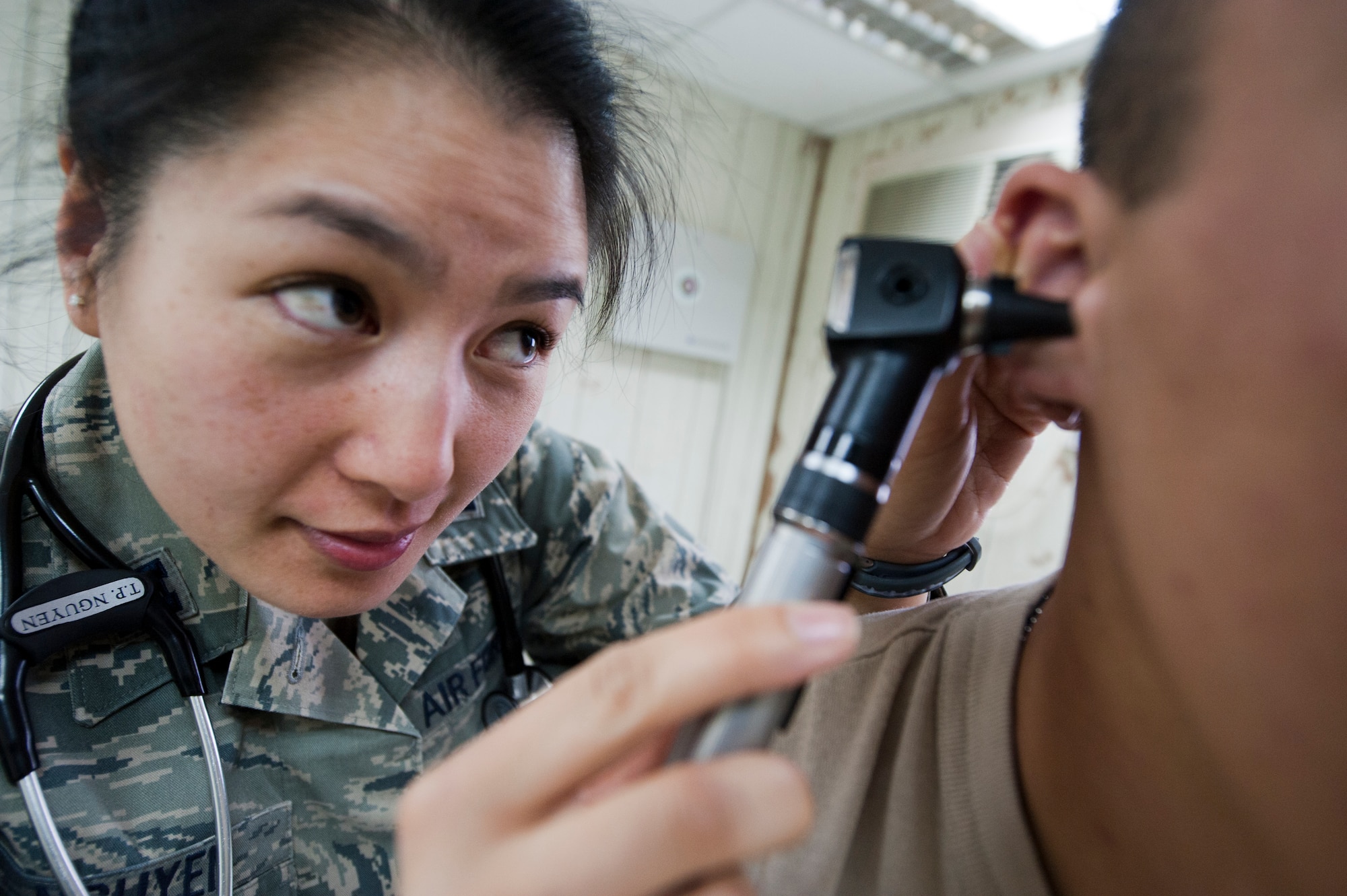 Capt. Thiennga Nguyen, 332nd Expeditionary Medical Group doctor, uses an otoscope to check for an ear infection on a patient in an undisclosed location in Southwest Asia, Jan. 19, 2012. Nguyen and fellow health care providers use otoscopes to screen for illness during regular check-ups, the otoscope, makes it possible to see the outer and middle inner. Nguyen is deployed from Misawa Air Base, Japan and is a native of Albuquerque, N.M.. (U.S. Air Force photo by Staff Sgt. Joshua J. Garcia/Released)