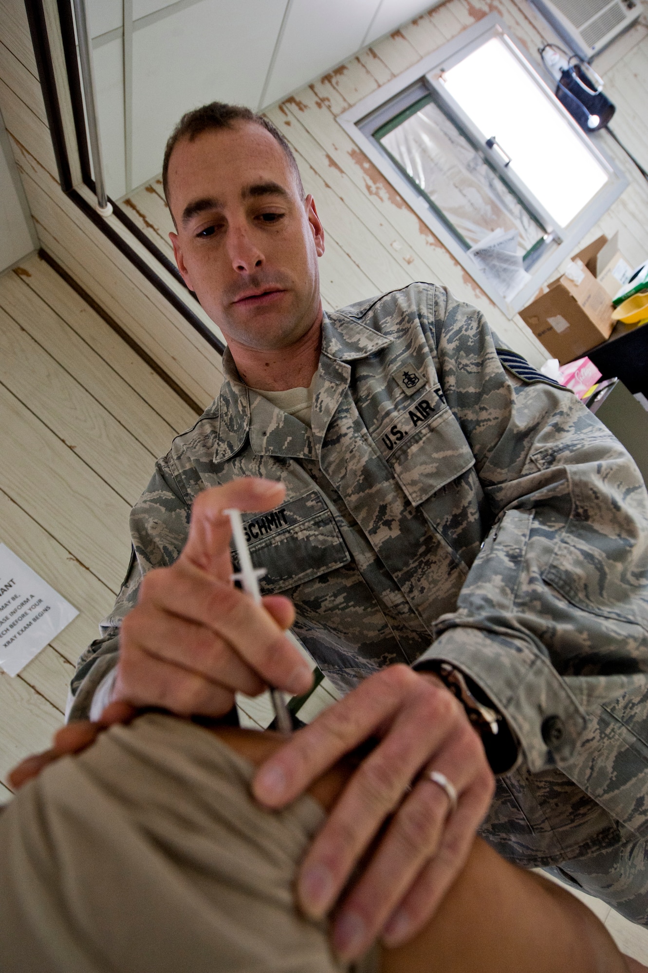Tech. Sgt. Brian Schmit, 332nd Expeditionary Medical Group medical technician, delivers an immunization shot to a patient in an undisclosed location in Southwest Asia, Jan 19, 2012. Schmit and fellow medical personnel handle all non-emergency services for the 332nd Air Expeditionary Wing.  Schmit is deployed from Spangdahlem Air Base, Germany, and is a native of Rogers Ark. (U.S. Air Force photo by Staff Sgt. Joshua J. Garcia/Released) 