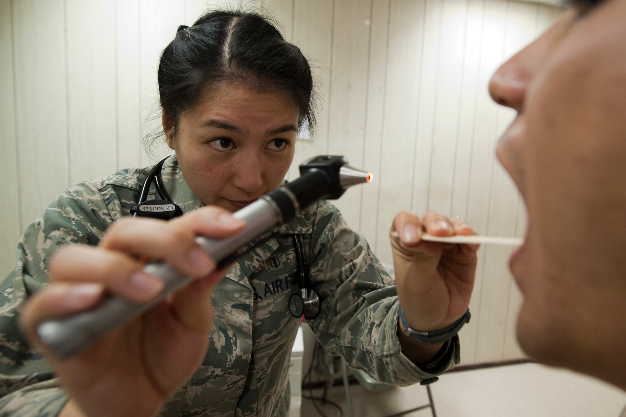 Capt. Thiennga Nguyen, 332nd Expeditionary Medical Group doctor, checks the back of a patients throat during a routine examine at an undisclosed location in Southwest Asia, Jan. 19, 2012. The examination can reveal signs of infection. Nguyen is deployed from Misawa Air Base, Japan and is a native of Albuquerque, N.M. (U.S. Air Force photo by Staff Sgt. Joshua J. Garcia/Released)