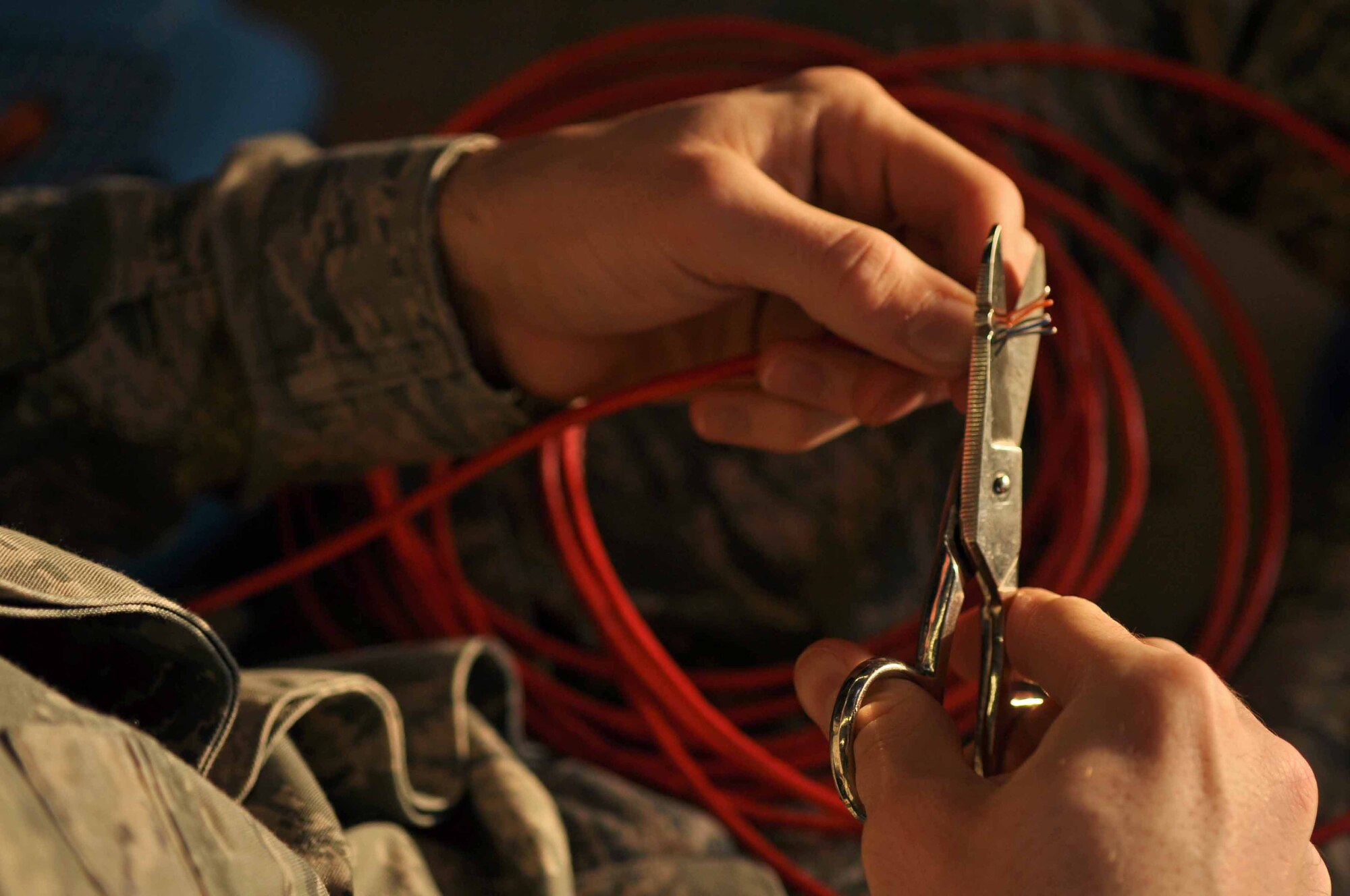 SPANGDAHLEM AIR BASE, Germany -- Airman 1st Class Garret Breit, 606th Air Control Squadron cyber transport systems operator, cuts a network cable during a communications maintenance exercise here Jan. 18. This cable was used to connect a laptop to servers simulating a deployable network.  The purpose of the exercise is to train squadron members in maintaining communication practices by establishing satellite communications and setting up a theater-deployable communications package. (U.S. Air Force photo/Senior Airman Natasha Stannard)