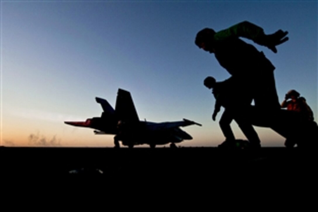 Flight deck crew members launch an F/A-18F Super Hornet from the flight deck aboard the aircraft carrier USS Carl Vinson in the Arabian Sea, Jan. 18, 2012. The Carl Vinson and Carrier Air Wing 17 are deployed to the U.S. 5th Fleet area of responsibility. The crew members are assigned to Strike Fighter Squadron 22.