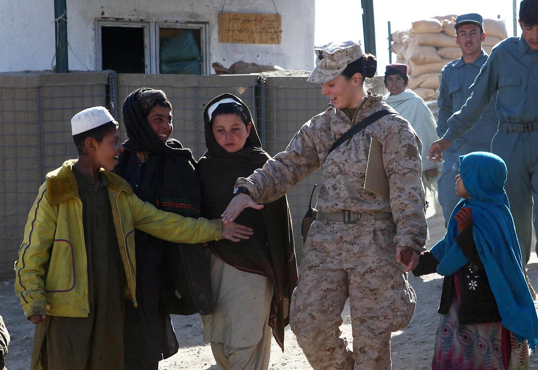 Navy Petty Officer 2nd Class Kimberley Ryan, team leader, Female Engagement Team, Marine Headquarters Group, holds hands with the local children just before a local shura near Forward Operating Base Jackson. Shura is the word for consultation or class. The children’s shuras are held once a week and are geared toward educating the children.