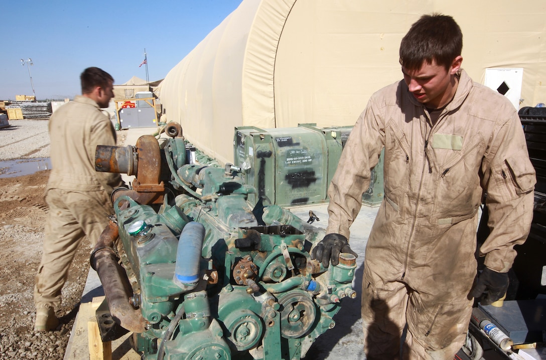 British Army soldiers Craftsman Adam Evans (left) and Lance Cpl. Craig Heaton (right) troubleshoot a Detroit Diesel V6 Logistics Vehicle System truck engine at the Intermediate Maintenance Activity lot aboard Camp Leatherneck, Afghanistan, Jan. 20. The pair spent a week learning the Marine Corps methods of on-site maintenance and repair. (U.S. Marine Corps photo by Sgt. Justin J. Shemanski)
