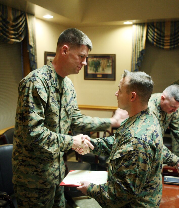 Petty Officer 1st Class Raymond R. Price, a corpsman with the Group Aid Station, 2nd Marine Logistics Group, shakes hands with Col. Mark Hollahan, the commanding officer for 2nd MLG, during a ceremony at the 2nd MLG headquarters building aboard Camp Lejeune, N.C., Jan. 20, 2012. During the ceremony Price received the 2011 2nd MLG Senior Sailor of the Year award for his outstanding achievements and performance during the past year. (U.S. Marine Corps photo by Pfc. Franklin E. Mercado)