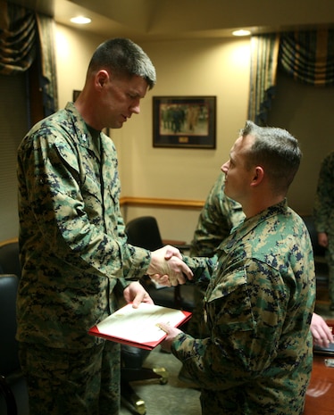 Col. Mark Hollahan, 2nd Marine Logistics Group commanding officer, presents Petty Officer 1st Class Raymond R. Price, a hospital corpsman with the 2nd MLG from Tarrant County, Texas, with the Navy and Marine Corps Achievement Medal for earning the title of Senior Sailor of the Year during a ceremony Jan. 20, 2012, aboard Camp Lejeune, N.C.  Price also received an engraved knife as well as a Letter of Appreciation on behalf of the command in recognition for his year-long efforts. (Photo by Cpl. Bruno J. Bego)