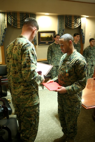 Col. Mark Hollahan, 2nd Marine Logistics Group commanding officer, presents Petty Officer 2nd Class Donnell Proctor, a hospital corpsman with the 2nd MLG from Baltimore, with the Navy and Marine Corps Achievement Medal for earning the title of Junior Sailor of the Year during a ceremony Jan. 20, 2012, aboard Camp Lejeune, N.C.  Proctor also received an engraved knife as well as a Letter of Appreciation on behalf of the command in recognition for his year-long efforts. (Photo by Cpl. Bruno J. Bego)