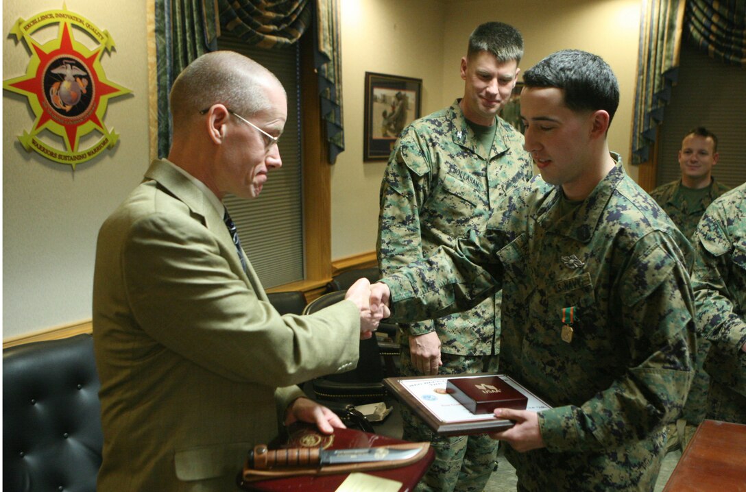 Kevin Jenkins, the operations manager for a local business, presents Seaman Joseph R. Morgott, a hospital corpsman with the 2nd MLG from New Orleans, with an engraved knife to recognize his year-long efforts that earned him the title of Blue Jacket of the Year during a ceremony Jan. 20, 2012, aboard Camp Lejeune, N.C.  Morgott also received the Navy and Marine Corps Achievement Medal as well as a Letter of Appreciation on behalf of the command. (Photo by Cpl. Bruno J. Bego)