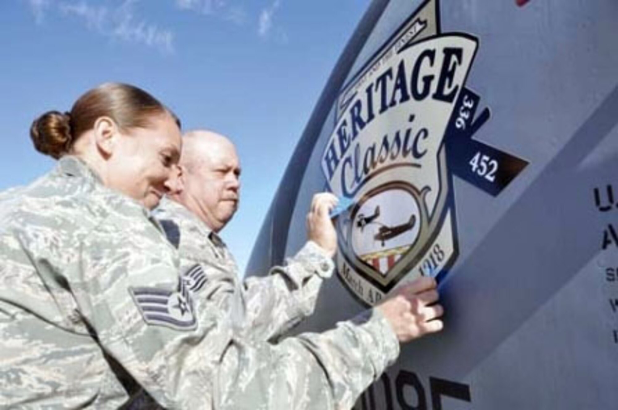 Staff Sgt. Erin Casillas and Tech. Sgt. Jaime Hase from the 452nd Maintenance Squadron at March Air Reserve Base, Calif., put the final touches on nose art they applied to a March KC-135 Stratotanker Dec. 12, 2011. U.S. Air Force photo by Megan Crusher