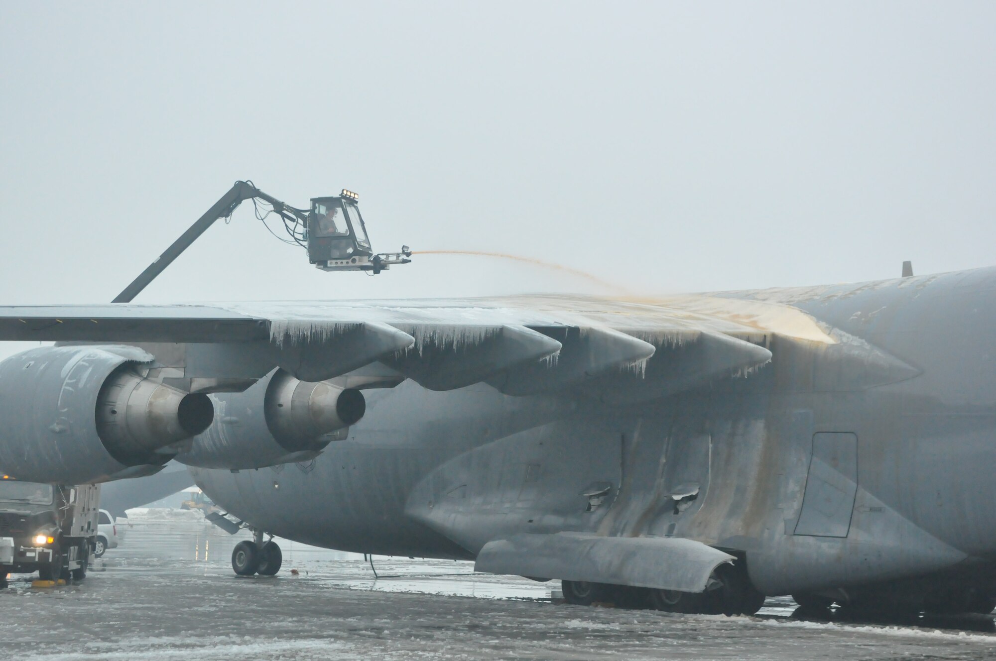 Airmen assigned to the 62nd Aircraft Maintenance Squadron maneuver a mobile truck mounted deicer on the McChord Field flightline as part of recovery efforts following a winter storm which accumulated more than nine inches of snow Jan. 20, 2012, at Joint Base Lewis-McChord, Wash. Deicing provides protection against ice buildup and snow contamination of critical controlled surfaces, engine inlets and sensors on the aircraft prior to launch. (U.S. Air Force photo/Airman 1st Class Leah Young)