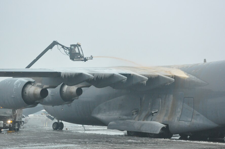Airmen assigned to the 62nd Aircraft Maintenance Squadron maneuver a mobile truck mounted deicer on the McChord Field flightline as part of recovery efforts following a winter storm which accumulated more than nine inches of snow Jan. 20, 2012, at Joint Base Lewis-McChord, Wash. Deicing provides protection against ice buildup and snow contamination of critical controlled surfaces, engine inlets and sensors on the aircraft prior to launch. (U.S. Air Force photo/Airman 1st Class Leah Young)