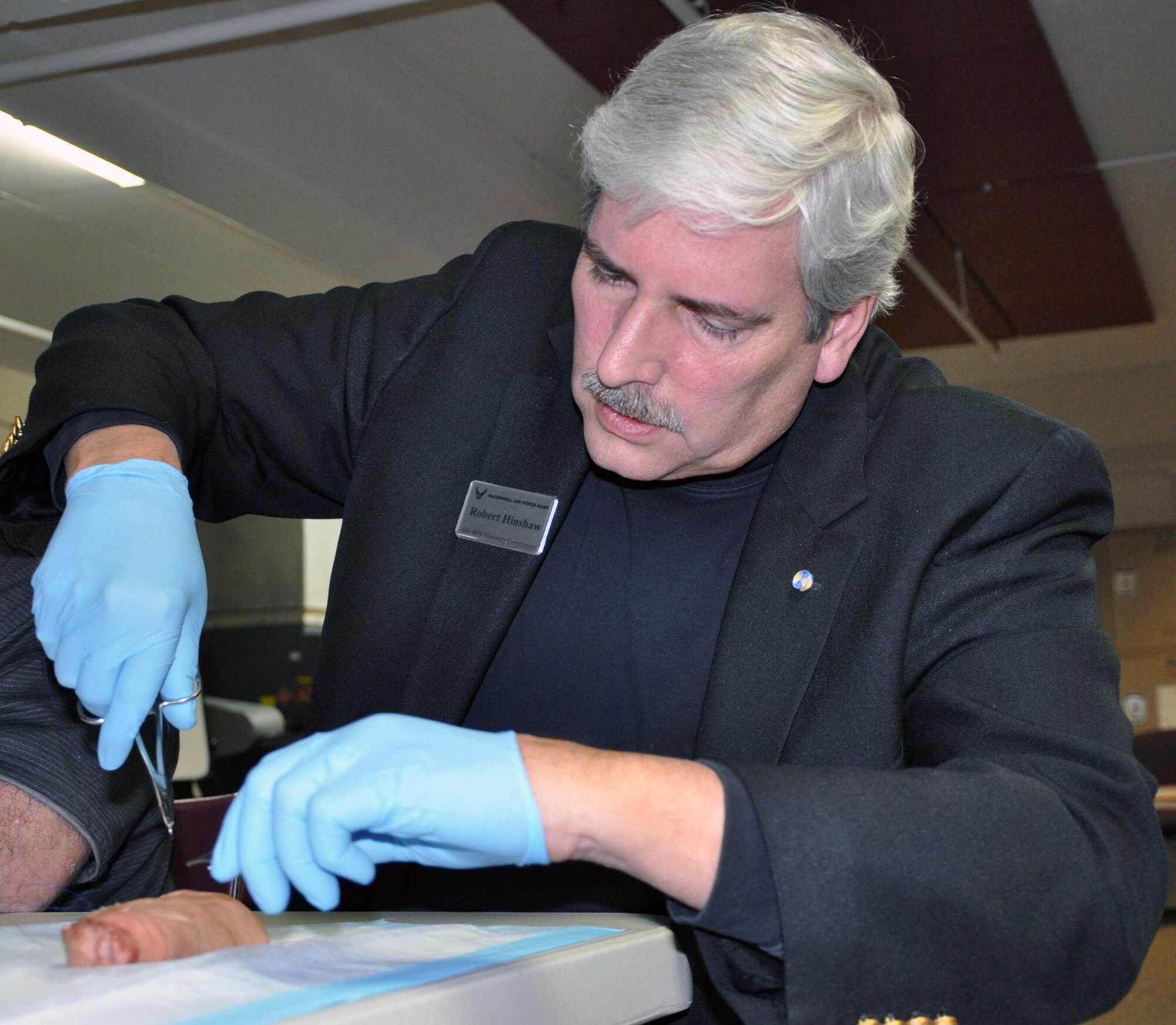 Robert Hinshaw, Sedgwick County Sheriff and Honorary Commander of the 931st Security Forces Squadron, receives some hands-on training on performing sutures during a McConnell Air Force Base Honorary Commander orientation event, Jan. 20, 2012.  McConnell Honorary Commanders attended a luncheon, were briefed on the medical mission at McConnell, and were able to participate in medical training activities.  (U.S. Air Force photo by 1st Lt. Zach Anderson)  