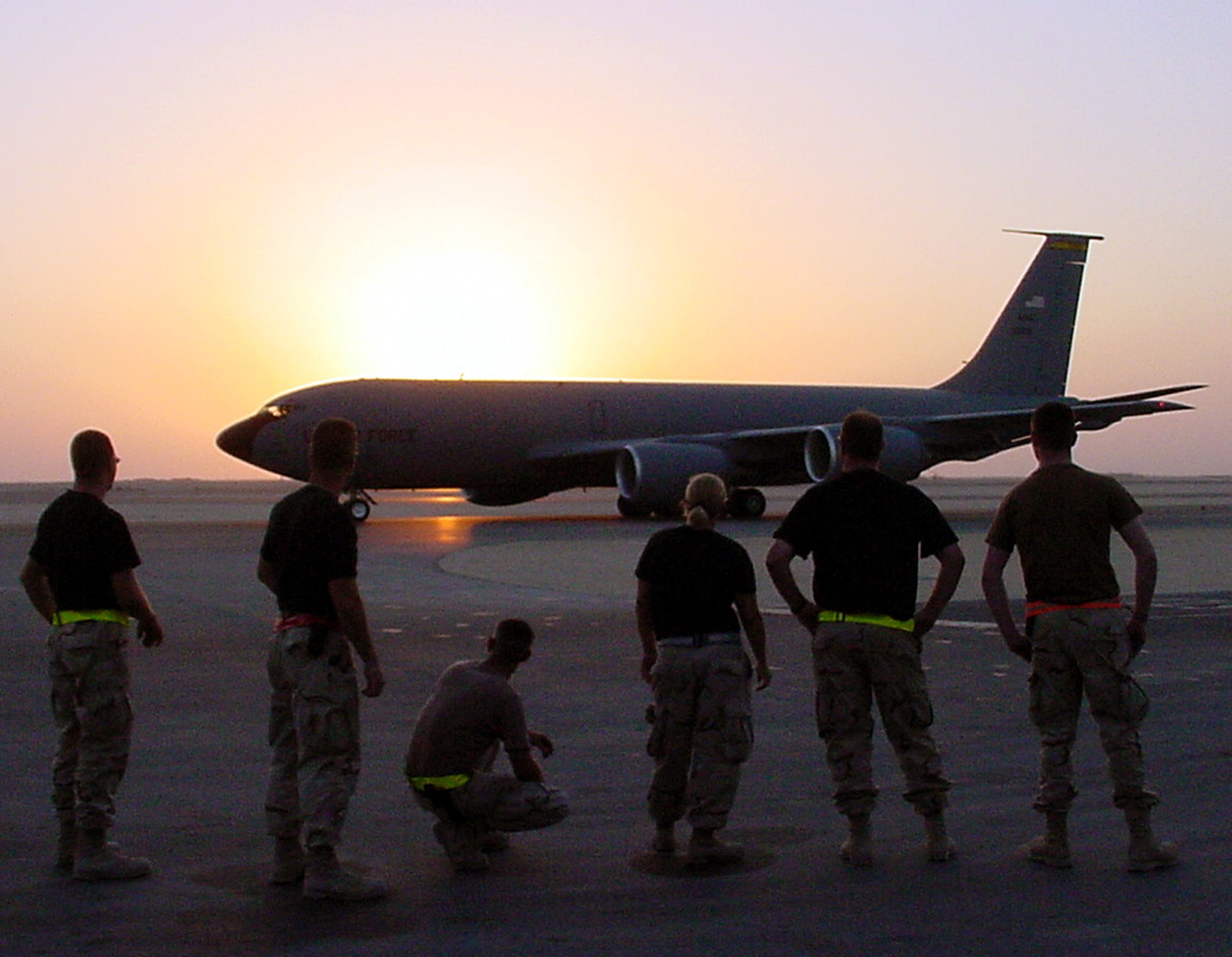 Tanker maintenance troops from the 319th Air Refueling Wing at Grand Forks Air Force Base, N.D., watch as a tanker from the 22nd ARW at McConnelll AFB, Kan., rolls off into the sunset for a night air refueling mission for Operation Iraqi Freedom from a non-disclosed base in Southwest Asia on Sept. 28, 2003. Tanker units from Grand Forks; McConnell; MacDill AFB, Fla; Robins AFB, Ga.; and Fairchild AFB, Wash., combined for a short time in 2003 to work together in the 340th Expeditionary Air Refueling Squadron. (U.S. Air Force photo by Master Sgt. Scott T. Sturkol)