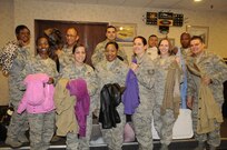 Members of Joint Base San Antonio-Randolph Rising 5/6 hold up the coats collected during “Cold Days, Warm Hearts,” during their meeting at the Parr Club, Jan 20. The professional organization collected serviceable coats and jackets, took them to the cleaners and are planning to distribute the coats to local charities around San Antonio. The goal was 50 coats but the organization far exceeded their goal by collecting 98 coats. 
(U.S. Air Force photo by Airman 1st Class Airman Siekert)

