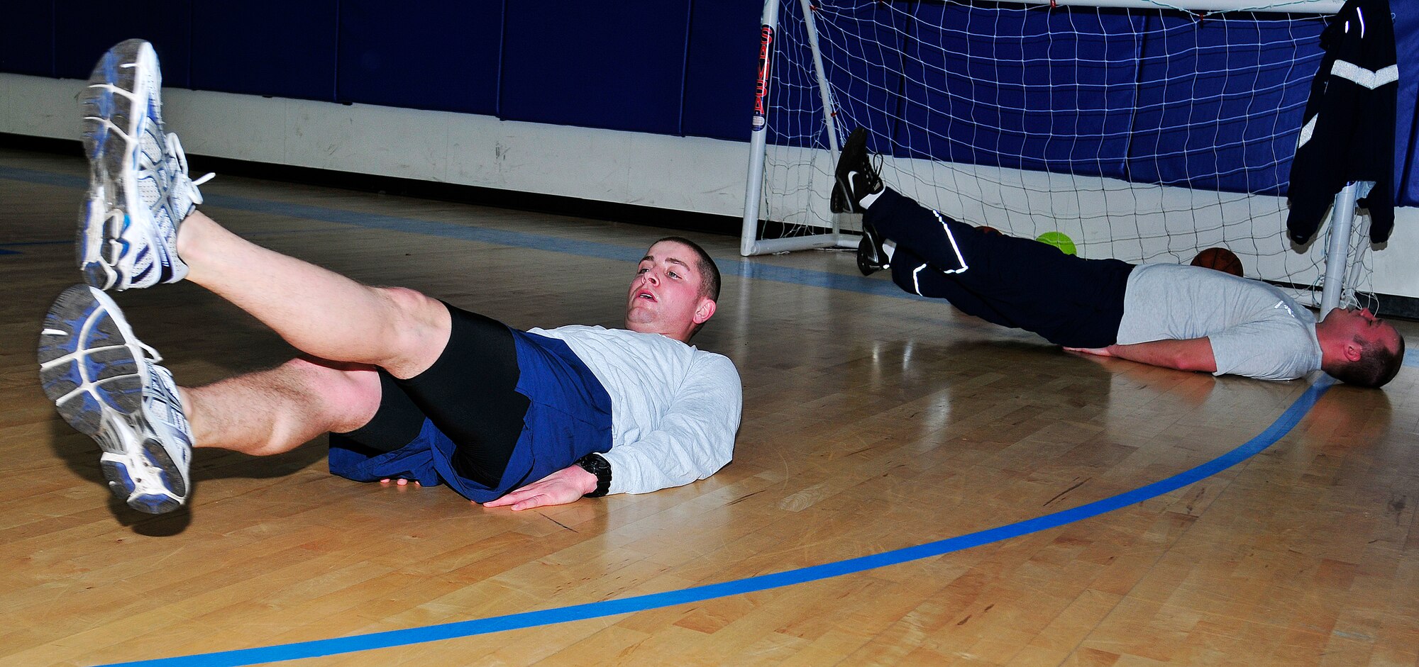 Senior Airman Steven Evans, (left) the 48th Security Forces Squadron physical training leader, scissor-kicks along with his fellow 48th SFS members during their workout at Royal Air Force Lakenheath, England, Jan. 12, 2012. Fitness has been an integral part of Evans' life since he was a child. (U.S. Air Force photo/Senior Airman Tiffany M. Deuel)