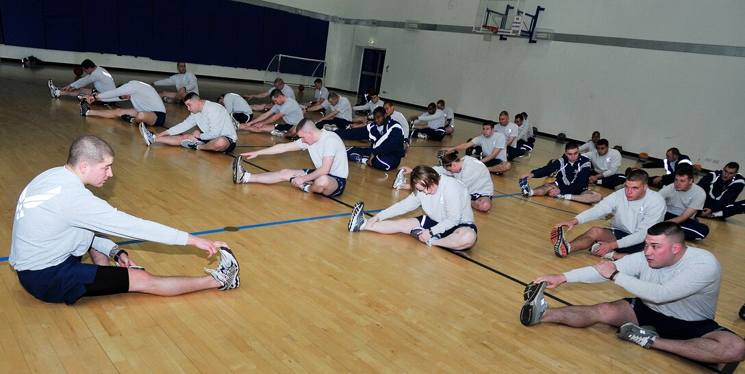 Senior Airman Steven Evans, (left) the 48th Security Forces Squadron physical training leader, leads fellow 48th SFS members in a stretch during their workout at Royal Air Force Lakenheath, England, Jan. 12, 2012. Evans was selected by senior leadership to re-design their squadron physical training program. (U.S. Air Force photo/Senior Airman Tiffany M. Deuel)