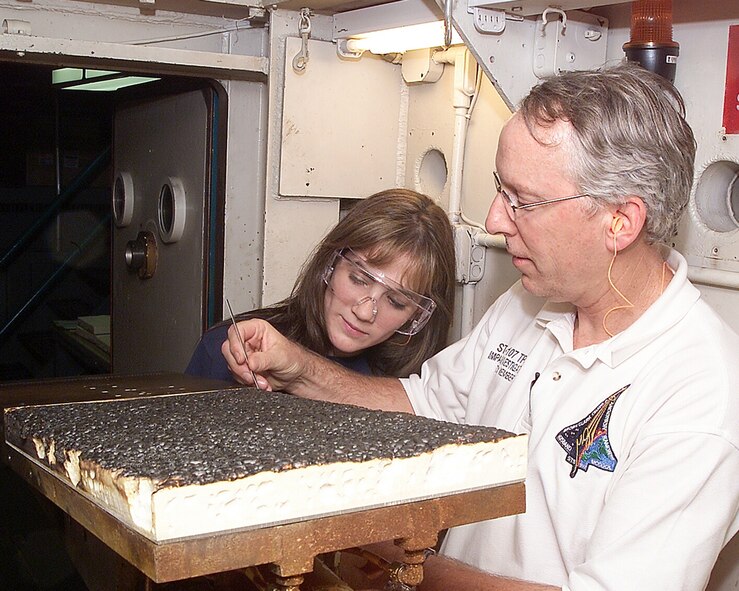 Philip Kopfinger, NASA test engineer, and Katie Carr, a NASA intern, examine a section of foam paneling of the type used on the Space Shuttle’s main exterior fuel tank during liftoff. Following the breakup of Columbia during re-entry in February 2003, AEDC facilities and personnel responded to help NASA return to manned space flight. The successful final flight of the Space Shuttle last year was, in large part, a result of testing at AEDC. (Photo by David Housch)