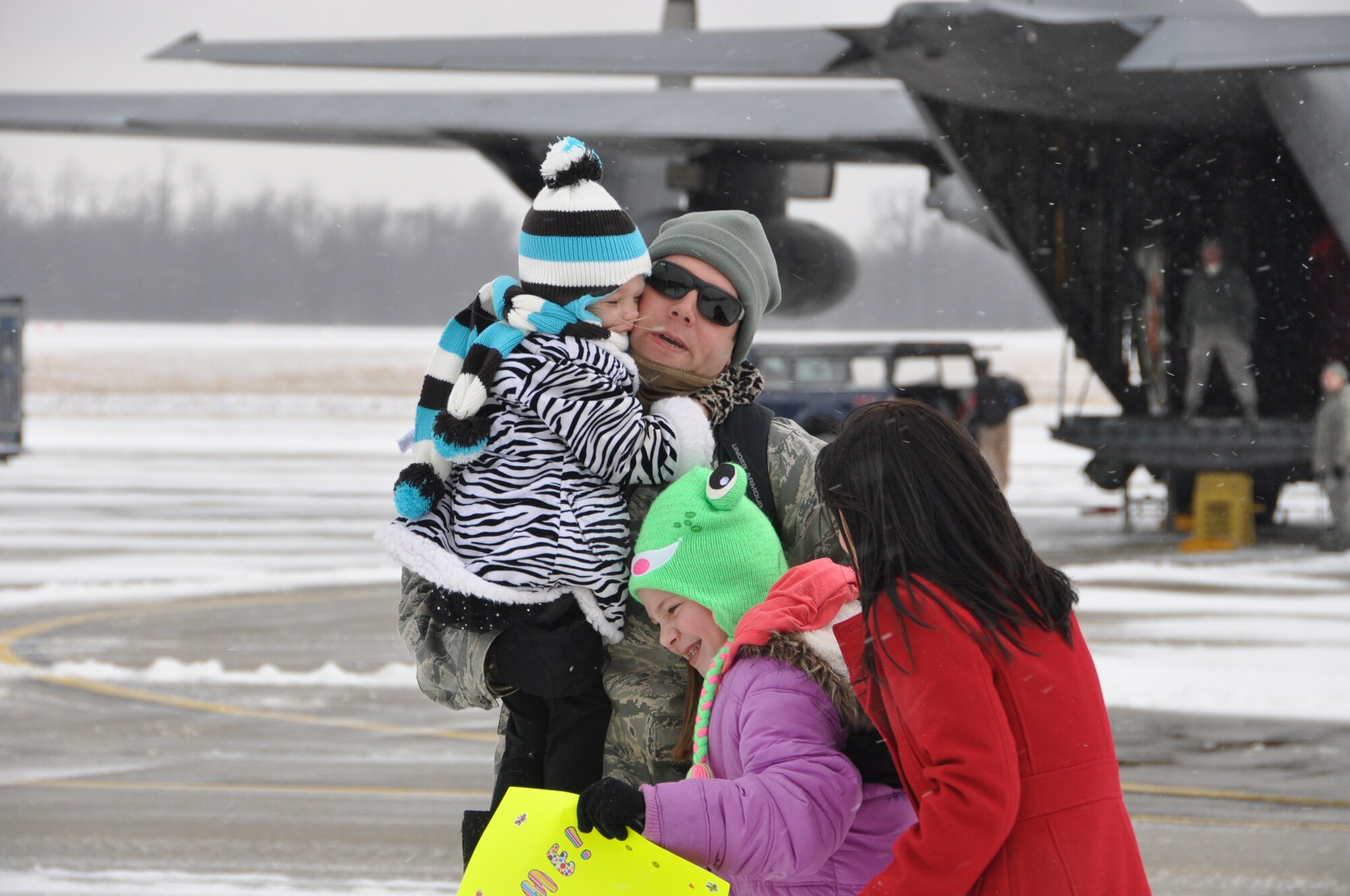 YOUNGSTOWN AIR RESERVE STATION, Ohio – Air Force Reserve Master Sgt. Dan Bryant, a communications/navigation systems craftsman assigned to the 910th Maintenance Squadron, is greeted by his daughters and his wife, Lori, as he arrives on the flightline here, Jan. 19, 2012. Bryant is one of approximately 40 Citizen Airmen that are the last of more than 140 Air Force Reservists, assigned to the 910th Airlift Wing’s flying and maintenance squadrons based at YARS, returning to Northeast Ohio after a 120-day deployment to Southwest Asia. While deployed, the 910th Servicemembers supported airlift operations to various military installations throughout the U.S. Central Command (USCENTCOM) Area of Operations (AOR). U.S. Air Force photo by Master Sgt. Bob Barko Jr.