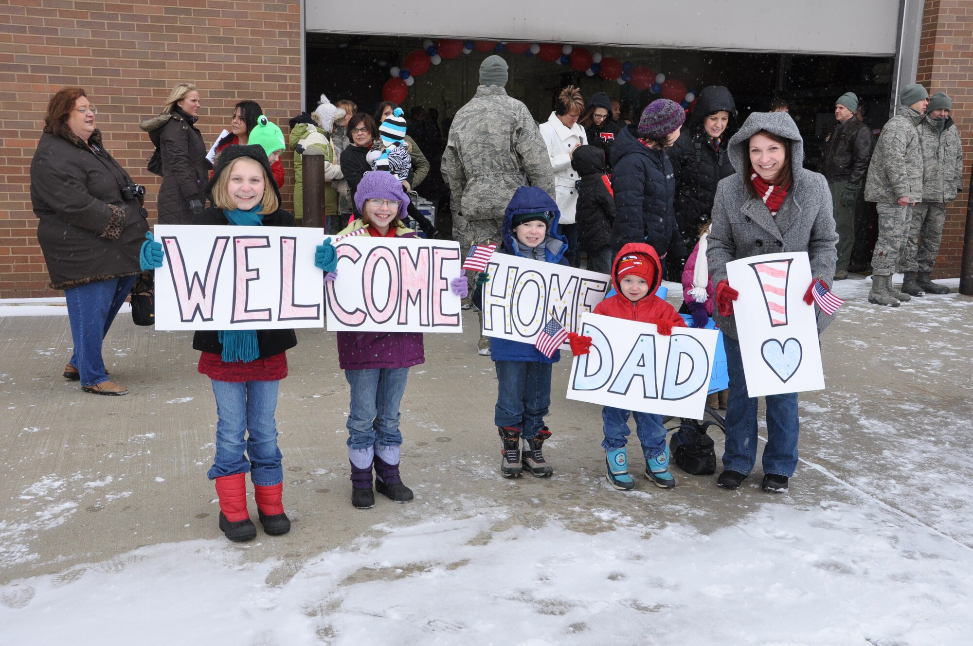 YOUNGSTOWN AIR RESERVE STATION, Ohio – The family of Air Force Reserve Staff Sgt. Christopher O’Neill, a loadmaster assigned to the 773rd Airlift Squadron, hold signs welcoming him home on the flightline here, Jan. 19, 2012. O’Neill is one of approximately 40 Citizen Airmen that are the last of more than 140 Air Force Reservists, assigned to the 910th Airlift Wing’s flying and maintenance squadrons based at YARS, returning to Northeast Ohio after a 120-day deployment to Southwest Asia that supported to airlift operations to various military installations throughout the U.S. Central Command (USCENTCOM) Area of Operations (AOR). U.S. Air Force photo by Master Sgt. Bob Barko Jr.