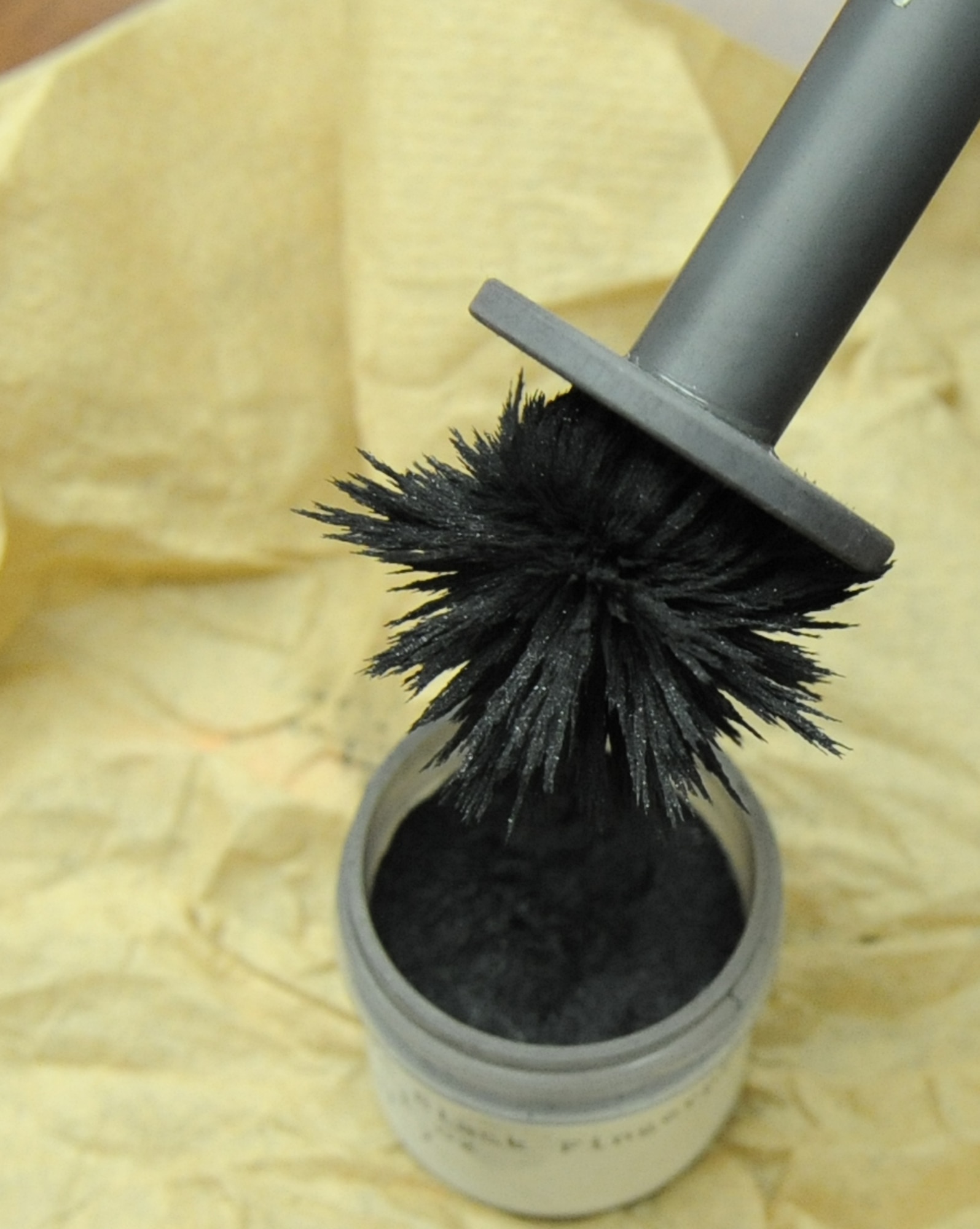 Special Agent Adam Deem, Air Force Office of Special Investigation Detachment 219, dips a magnetic wand into magnetic dusting powder at Barksdale Air Force Base, La., Jan.18. The magnetic applicator allows the dust to be moved gently across a surface without any bristles to damaging the print.(U.S. Air Force photo/Airman 1st Class Micaiah Anthony)(RELEASED)
