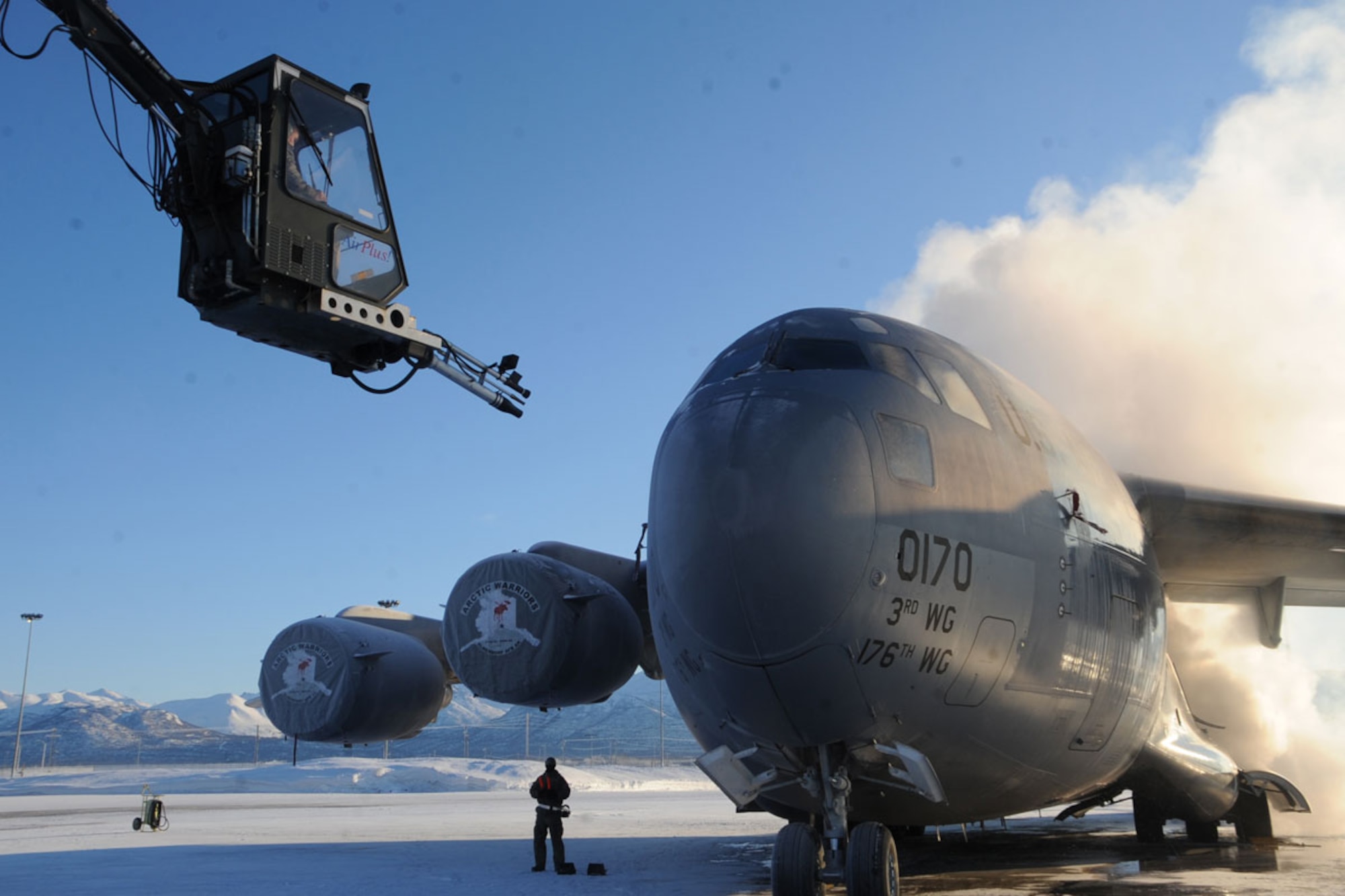 Airman 1st Class Jesse Stewart controls a global ground support aircraft deicer to remove snow from a C-17 Globemaster III Jan. 12. The deicing season usually lasts from October to April. Stuart is a C-17 crew chief with the 703rd Aircraft Maintenance Squadron and hails from Brilliant, Ohio. (U.S. Air Force photo/Staff Sgt. Cynthia Spalding)