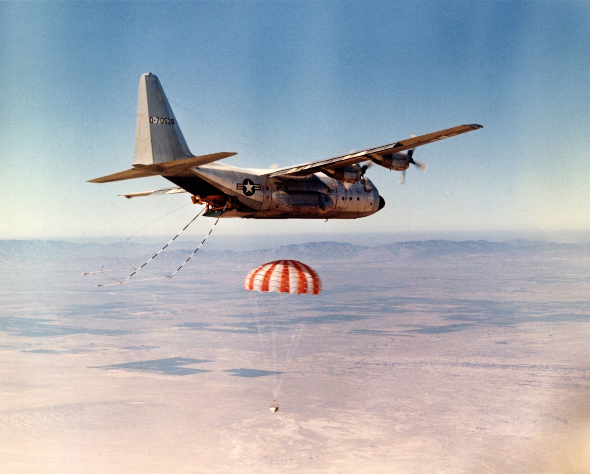 An Air Force JC-130B practices catching a satellite “bucket” with grappling gear and winch at Edwards AFB, Calif., 1969. (U.S. Air Force photo)
