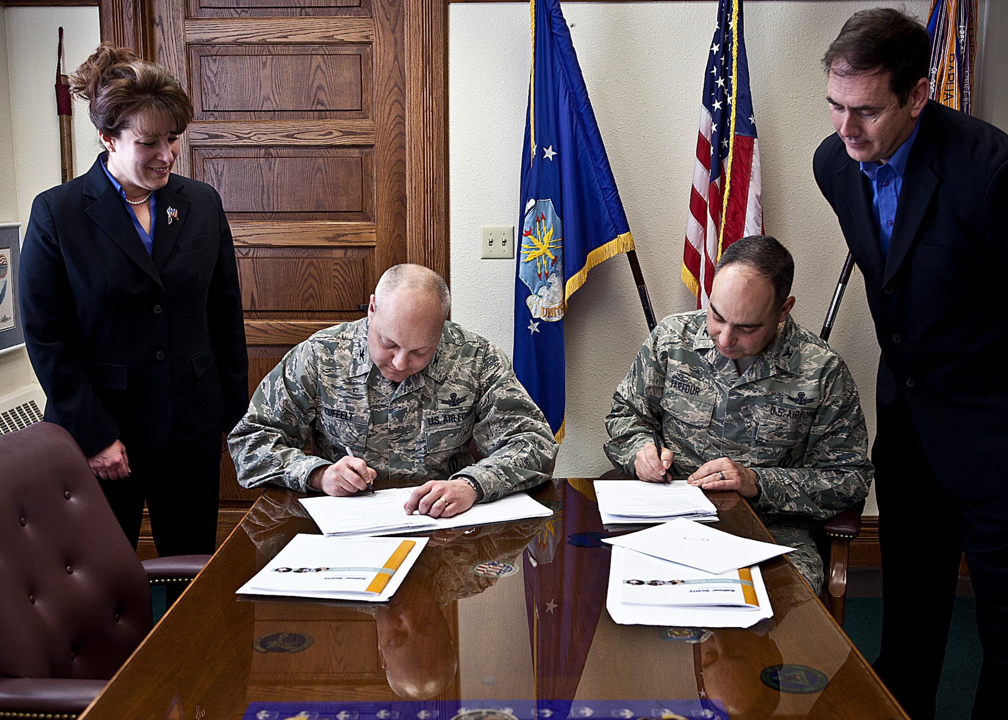 Col. Christopher Coffelt, 90th Missile Wing commander, and Col. George Farfour, 90th MW vice commander, sign their leases in accordance with the privatization of housing on F. E. Warren as Kimberly Patterson, Balfour Beatty Communities community manager, and Pat Hoppaugh, Western Group Area Communities manager, look on Jan. 17. (U.S. Air Force photo by Matt Bilden)