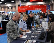 Military and civilian attendees  sign up for a free giveaway  at the USAA booth during the Air Education Training Command 2012 Symposium held in San Antonio, Texas, January 12 - 13. (U.S. Air Force photo by Don Lindsey)