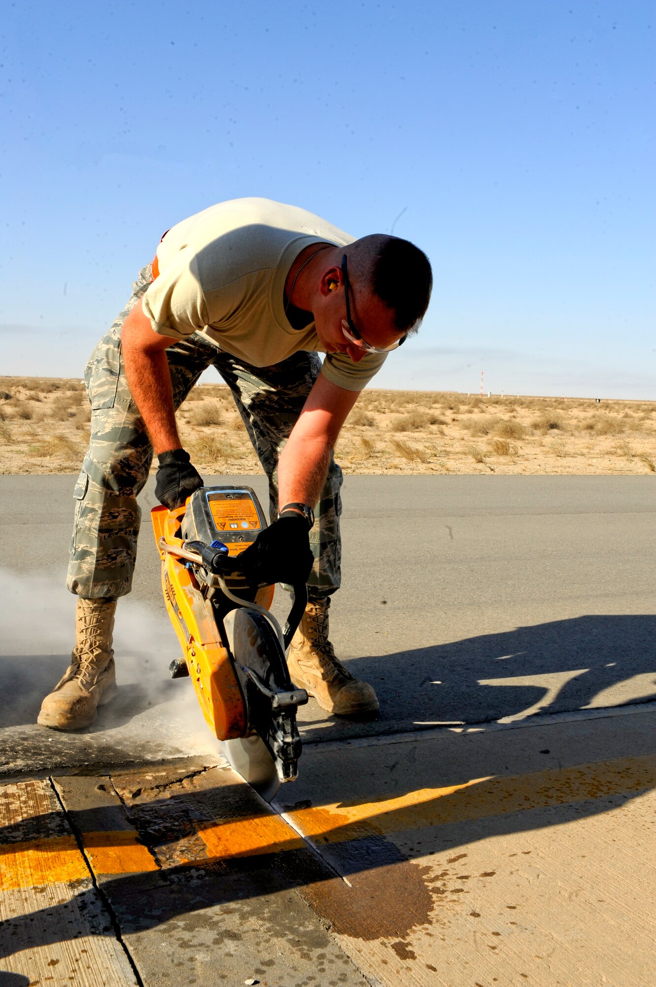 Staff Sgt. Matthew Sywassink, 332nd Expeditionary Civil Engineer Squadron heavy equipment operator, cuts an outline of a damaged area on the runway at an undisclosed location in Southwest Asia, Jan. 20, 2012. The outline shows the team the amount of runway that needs to be replaced. Sywassink is native to New Boston, Ill. and is deployed from Davis-Monthan Air Force Base, Ariz. (U.S. Air Force photo by Staff Sgt. Joshua J. Garcia/Released)