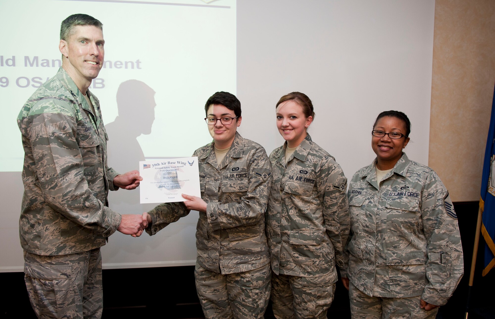 The 39th Operations Squadron Airfield Management Office receives the Ground Safety Team Award from Col. Chris Craige, 39th Air Base Wing commander, Jan. 19, 2012, at Incirlik Air Base, Turkey. Airfield management earned the award by performing actions preventing bird and wildlife aircraft strike hazards, as well as identifying and correcting wing tip violations with aerospace ground equipment. (U.S. Air Force photo by Senior Airman Clayton Lenhardt/Released)
