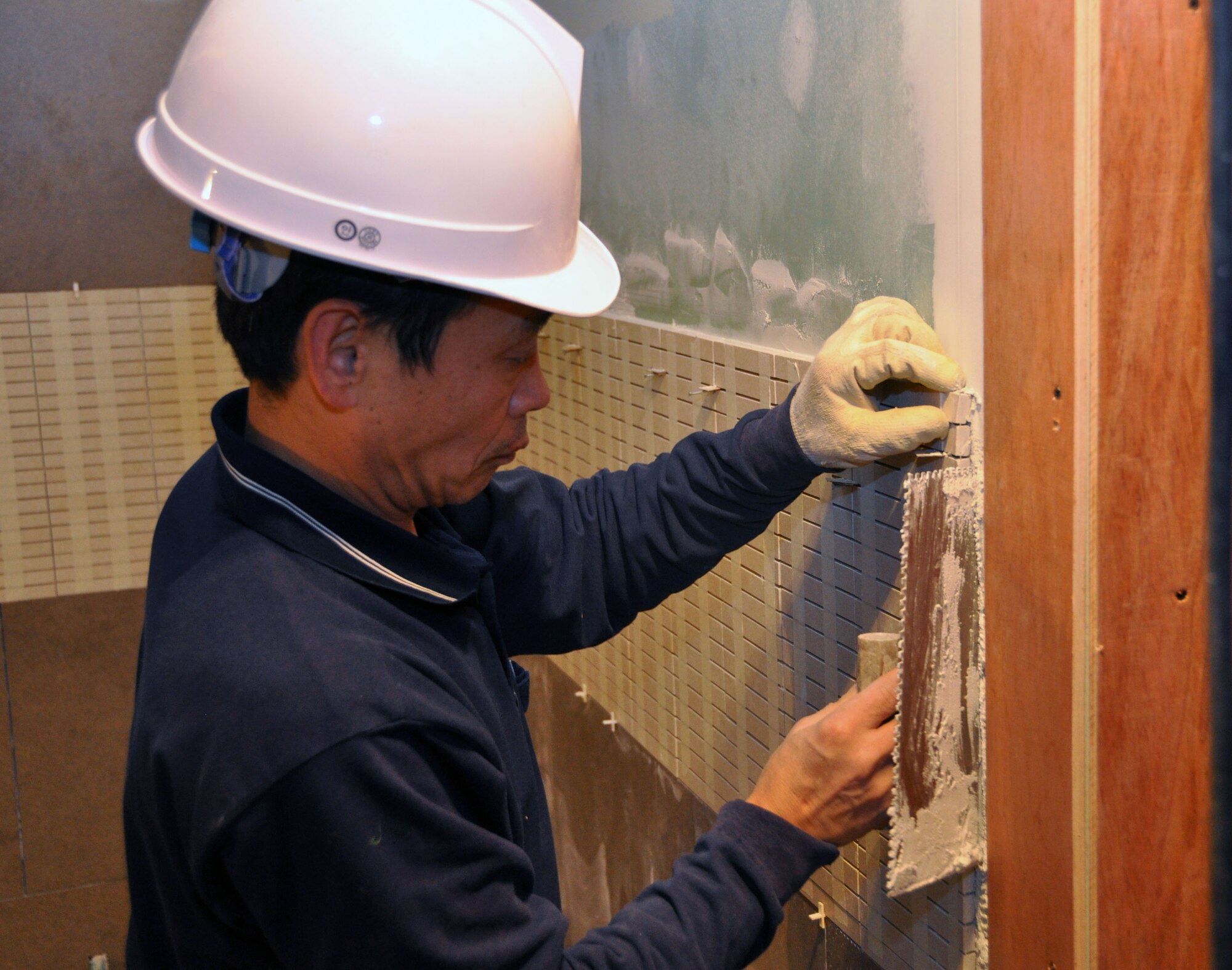 A contractor working with the 51st Civil Engineer Squadron applies wall mounts  in the newly built enlisted club, Jan. 11, 2012, at Osan Air Base, South Korea. (U.S. Air Force photo/Airman 1st Class Michael Battles) 
