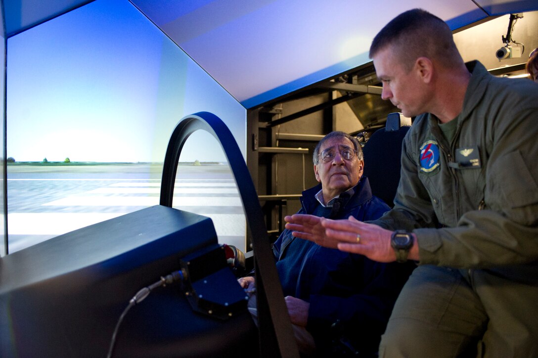 Marine Corps Lt. Col. Fred "Tinman" Schenk, right, explains the Joint Strike Fighter manned flight simulator to Defense Secretary Leon E. Panetta during the secretary's visit to Naval Air Station Patuxent River, Md., Jan. 20, 2012. 