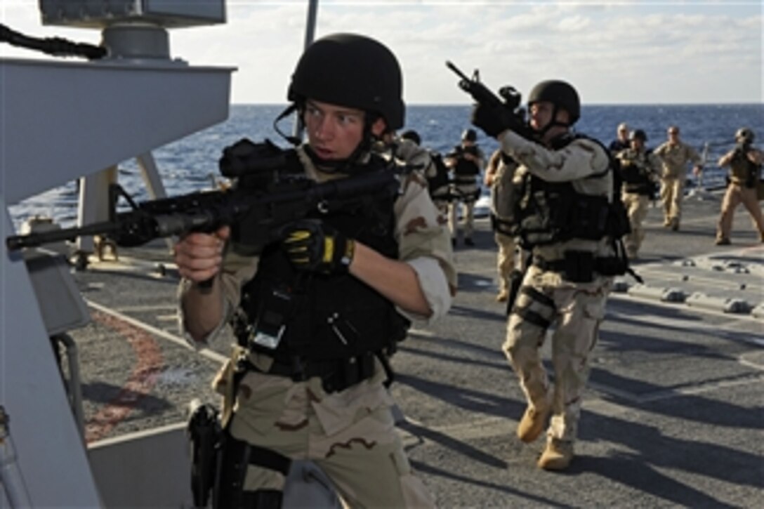 Petty Officer 2nd Class Matthew Burger, a visit, board, search and seizure team member aboard the guided-missile destroyer USS Dewey (DDG 105), leads his team across the missile deck toward the bridge during a joint-training exercise with U.S. Coast Guardsmen in the Red Sea on Jan. 14, 2012.  The Dewey is deployed to the U.S. 5th Fleet area of responsibility conducting maritime security operations.  