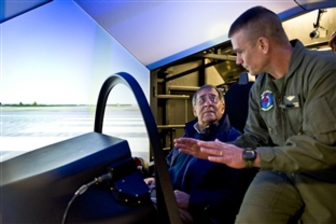 Defense Secretary Leon E. Panetta looks at the Joint Strike Fighter Manned Flight Simulator with Marine Corps Lt. Col. Fred "Tinman" Schenk on Naval Air Station Patuxent River, Md., Jan. 20, 2012. Panetta toured several facilities related to the F-35 Joint Strike Fighter, which is in its test phases at the base.
