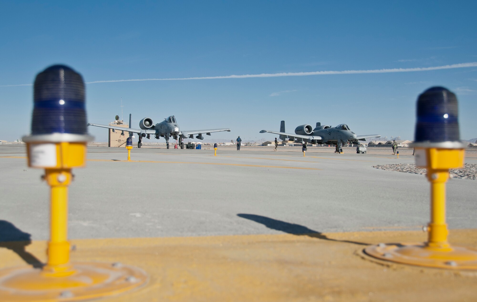 KANDAHAR AIRFIELD, Afghanistan -- Weapons load crew chiefs perform end-of-runway inspections on two A-10 Thunderbolt IIs at Kandahar Airfield, Afghanistan Jan. 20, 2012. The A-10 can employ a wide variety of conventional munitions, including general purpose bombs, cluster bomb units and laser guided bombs. (U.S. Air Force photo by Staff Sgt. David Carbajal)