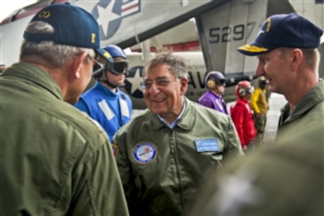 Defense Secretary Leon E. Panetta talks with Navy Capt. William C. Hamilton Jr., the commanding officer of the aircraft carrier USS Enterprise, upon arrival in the Atlantic Ocean, Jan. 21, 2012. The Enterprise Carrier Strike Group is conducting a composite training unit exercise.