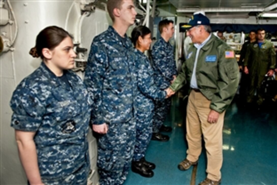 Defense Secretary Leon E. Panetta greets sailors upon arrival aboard the aircraft carrier USS Enterprise in the Atlantic Ocean, Jan. 21, 2012. The Enterprise Carrier Strike Group is conducting a composite training unit exercise.