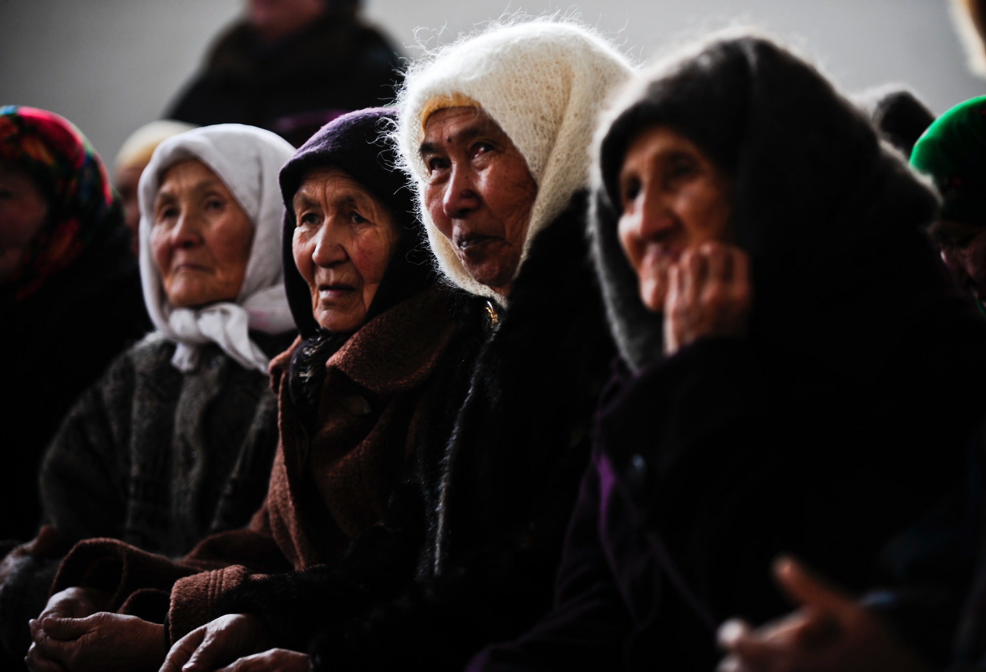 Kyrgyz women patiently wait for their turn to receive a winter coat Jan. 16, 2012, during an Operation Warm and Dry distribution in the Emgekchil School gymnasium in Sary-Oi, Kyrgyzstan. More than 50 Airmen from the 376th Air Expeditionary Wing the Transit Center at Manas volunteered their time to assist with the distribution in the Issyk-Kul region of Kyrgyzstan. (U.S. Air Force Photo/Staff Sgt. Angela Ruiz)