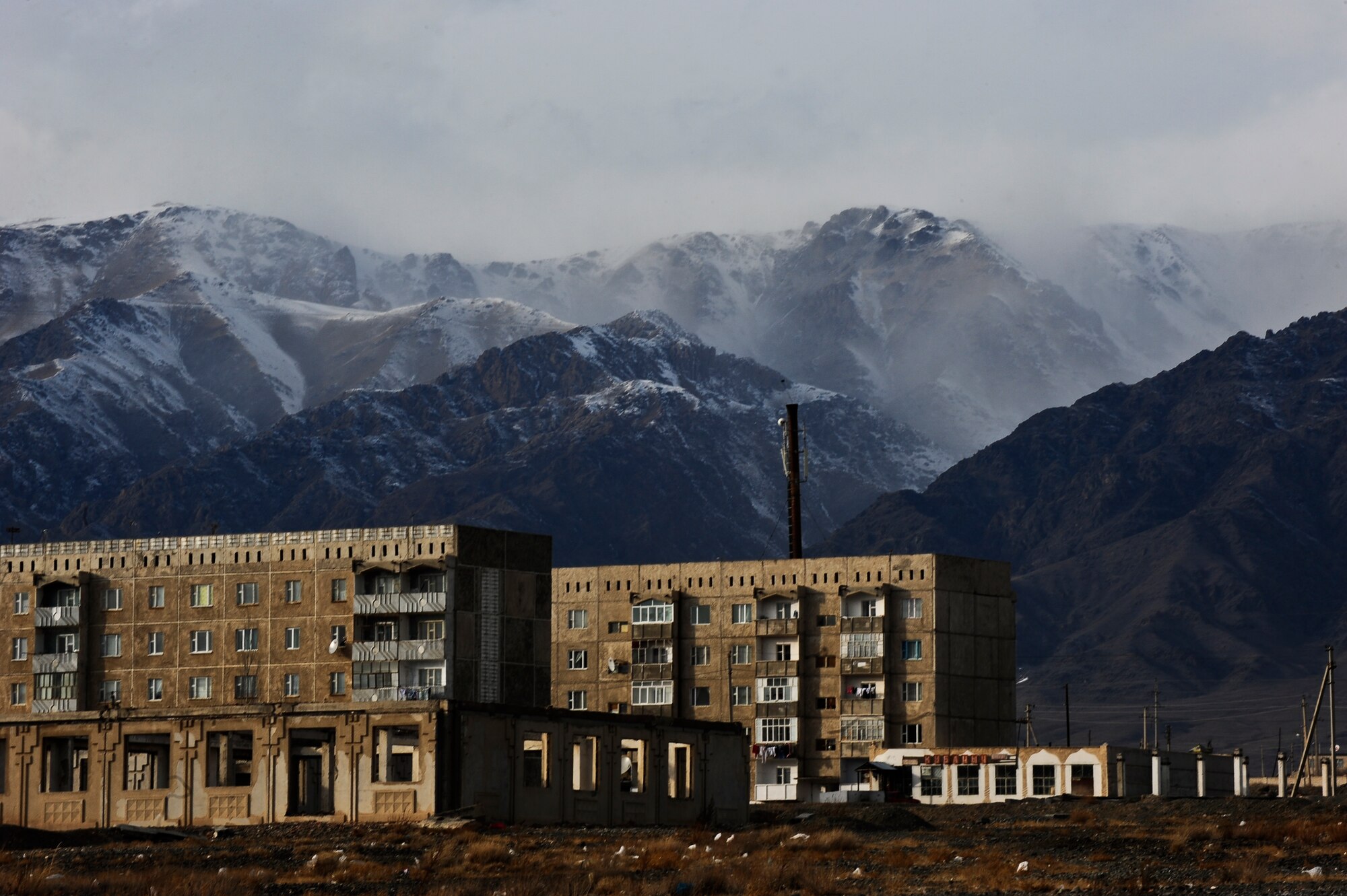 Apartment buildings stand close to mountains near a school that is being used as an Operation Warm and Dry distribution site in Balykchy, Kyrgyzstan, Jan. 15, 2012. This was the largest Operation Warm and Dry distribution this year. More than 1,000 coats and 200 blankets were given to Kyrgyz citizens at two locations in Balykchy during a five-day mission in the Issyk-Kul region. (U.S. Air Force Photo/Staff Sgt. Angela Ruiz)