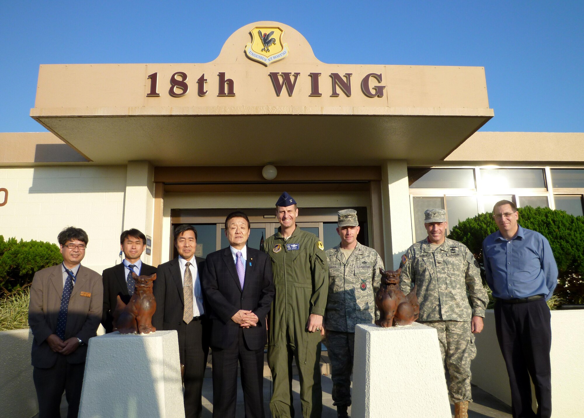 Japan's Vice Minister of Finance Mr. Yukihisa Fujita (center left) poses for a photo with U.S. Air Force Col. Corey Martin (center right), 18th Wing vice commander, along with other Japanese delegates and U. S. military personnel during his site visit to Kadena Air Base, Japan, Jan.18, 2012. Mr. Fujita received a briefing on different phases of Okinawa military housing renovations along with a tour of a home scheduled for demolition after reaching the expected 50-year lifespan. (Courtesy photo/Released)