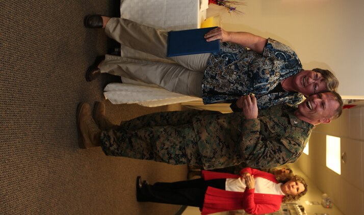 Col. Daniel J. Lecce, Marine Corps Base Camp Lejeune commanding officer, congratulates Kim Swensen, a Navy-Marine Corps Relief Society employee, for devoting 15 years of service to the society during the NMCRS birthday celebration at the NMCRS office, Jan. 23.