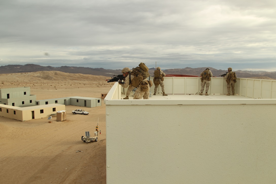 A fire team provides suppressing fire for Marines below from the roof of a building they cleared moments before during the Clear, Hold, Build 1 stage of their Enhanced Mojave Viper cycle Jan. 23, 2012.