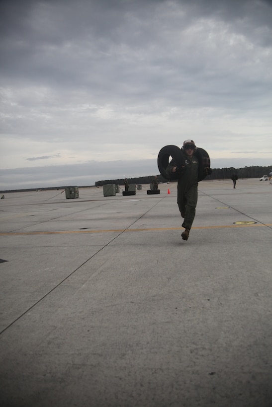 Sgt. Stephen Fink, an engine mechanic with Marine Attack Squadron 231 sprints with AV-8B Harrier tires in the “Feats of Strength” competition on the Marine Corps Air Station Cherry Point flight line Jan. 23. Previously the bimonthly competitions consisted of seasonal contests including an October pumpkin toss and December Christmas tree toss.