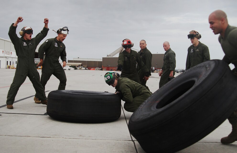 Aviation Marines with Marine Attack Squadron 231, “Ace of Spades,” wearing flightsuits and Marine Tactical Electronic Warfare Squadron 4, “Seahawks,” wearing Marine Corps Utilities flip the KC-130J tires in the last stretch of the “Feats of Strength” competition on the Marine Corps Air Station Cherry Point flight line Jan. 23. The “Ace of Spades” started with a strong lead but barley won with a neck-and-neck photo finish one tire lead. ::r::::n::::r::::n::
