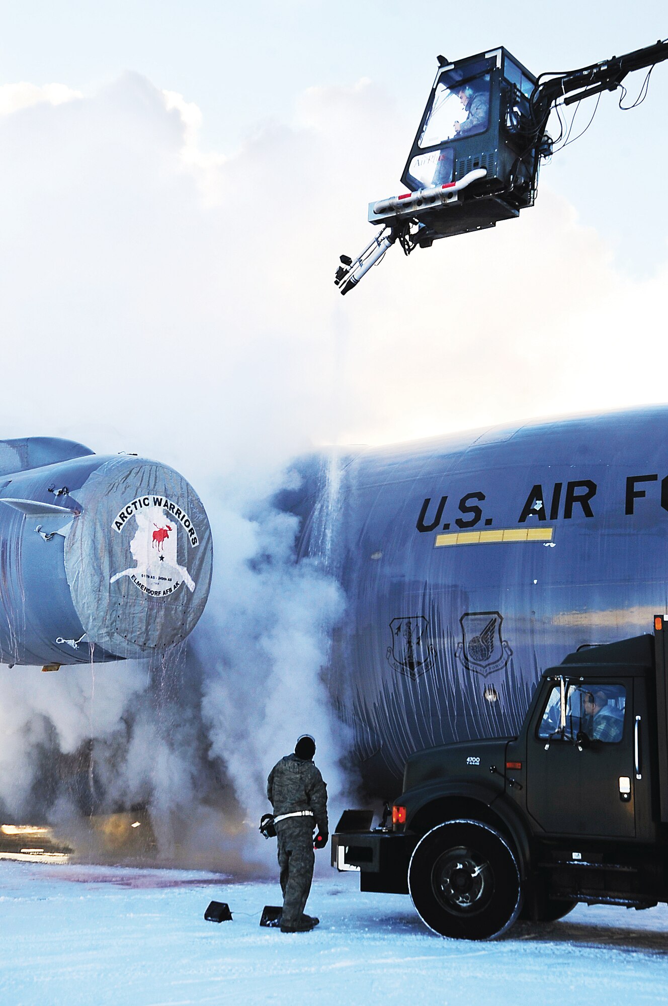 JOINT BASE ELMENDORF-RICHARDSON, Alaska -- Senior Airman Brandon Simmons stands watch as Airman 1st Class Jesse Stewart operates a global ground support aircraft deicer to remove frost from a C-17 Globemaster III assigned to the 3rd Wing, Jan. 17. The deicing season usually lasts from October to April. Simmons and Stewart are crew chiefs with the 703rd Aircraft Maintenance Squadron. Simmons is from Scott City, Mo., and Stewart is from Brilliant, Ohio. (U.S. Air Force photo/Staff Sgt. Cynthia Spalding)