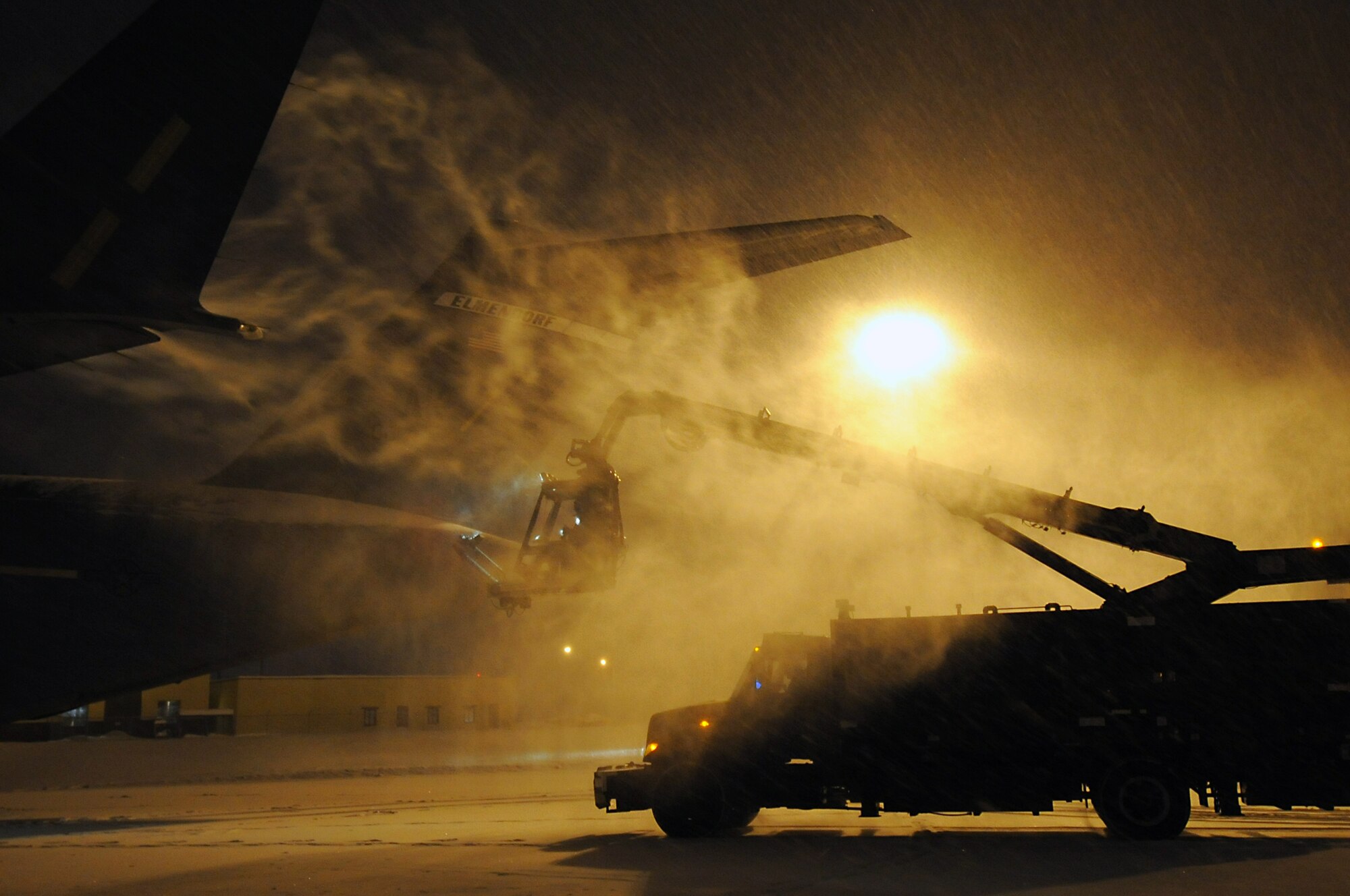 JOINT BASE ELMENDORF-RICHARDSON, Alaska -- Senior Airman Micheal Margagliotti is raised in the bucket seat of a global ground support aircraft deicer to remove snow from a C-17 Globemaster III, Jan. 12. The deicing season usually lasts from October to April. Margagioltti is a C-17 crew chief with the 703rd Aircraft Maintenance Squadron from Titusville, Fla. (U.S. Air Force photo/Staff Sgt. Cynthia Spalding)