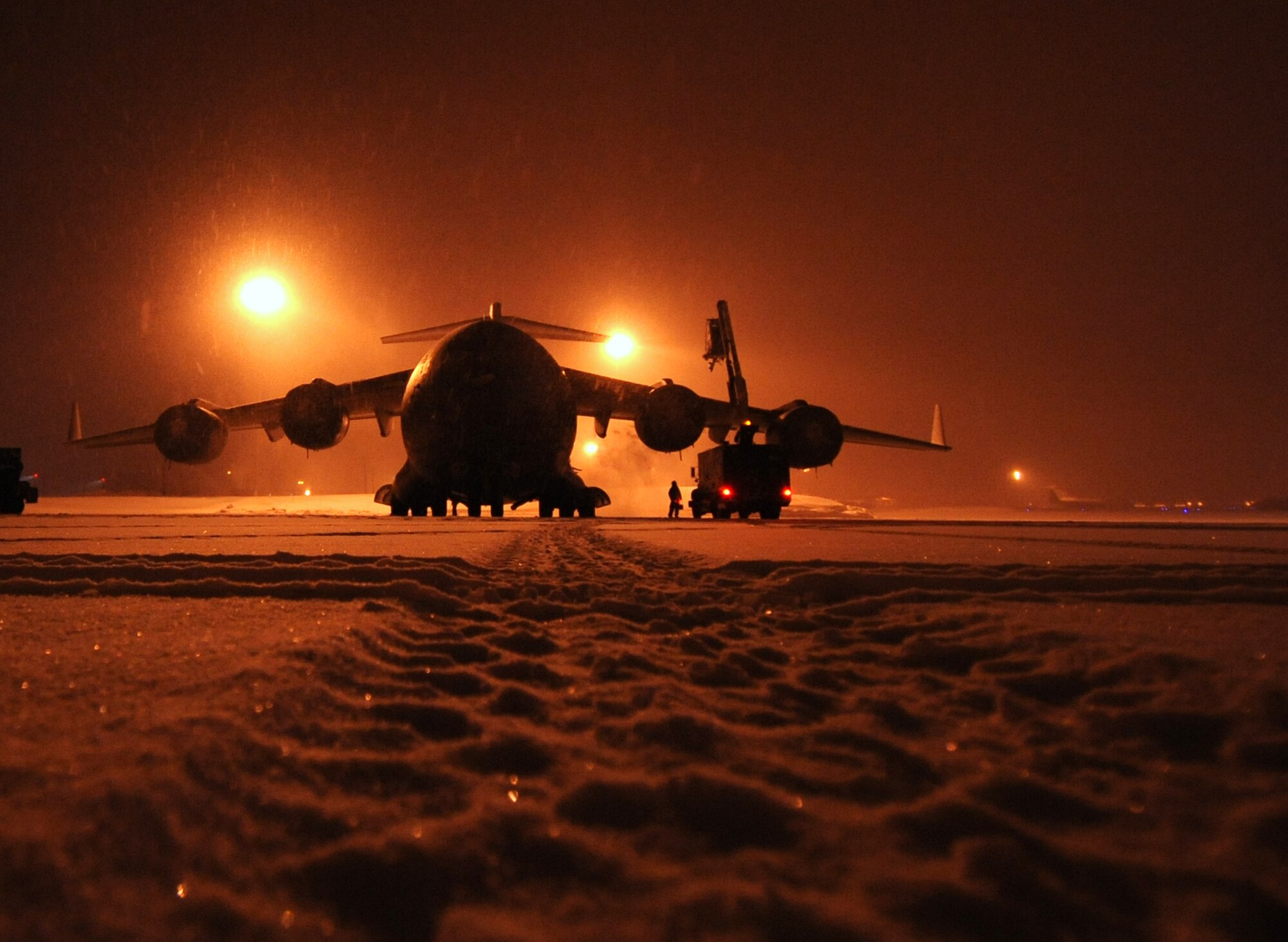 JOINT BASE ELMENDORF-RICHARDSON, Alaska -- On a snow-covered flight line, maintainers with the 703rd Aircraft Maintenance Squadron remove snow from a C-17 Globemaster III assigned to the 3rd Wing, Jan. 12. The deicing season usually lasts from October to April. (U.S. Air Force photo/Staff Sgt. Cynthia Spalding)