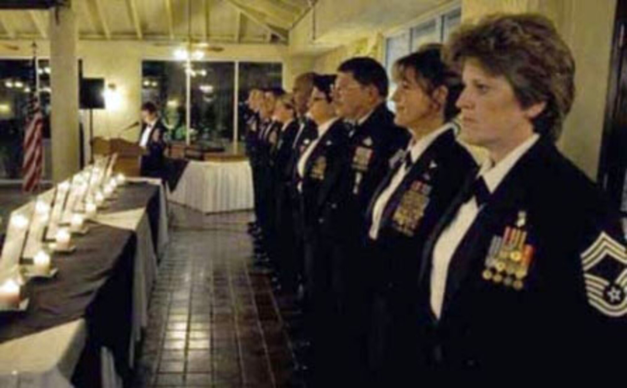 Eleven chief master sergeants stand at attention during the March Air Reserve base bi-annual Chief’s Induction Ceremony at the Hap Arnold Club here Jan. 8, while Chief Master Sgt. Deb McGuane, 336th Air Refueling Squadron, reads the history of the ceremony. McGuane is the president of the Team March Chief’s Group. (U.S. Air Force photo / Tech. Sgt. Erica Knight)

