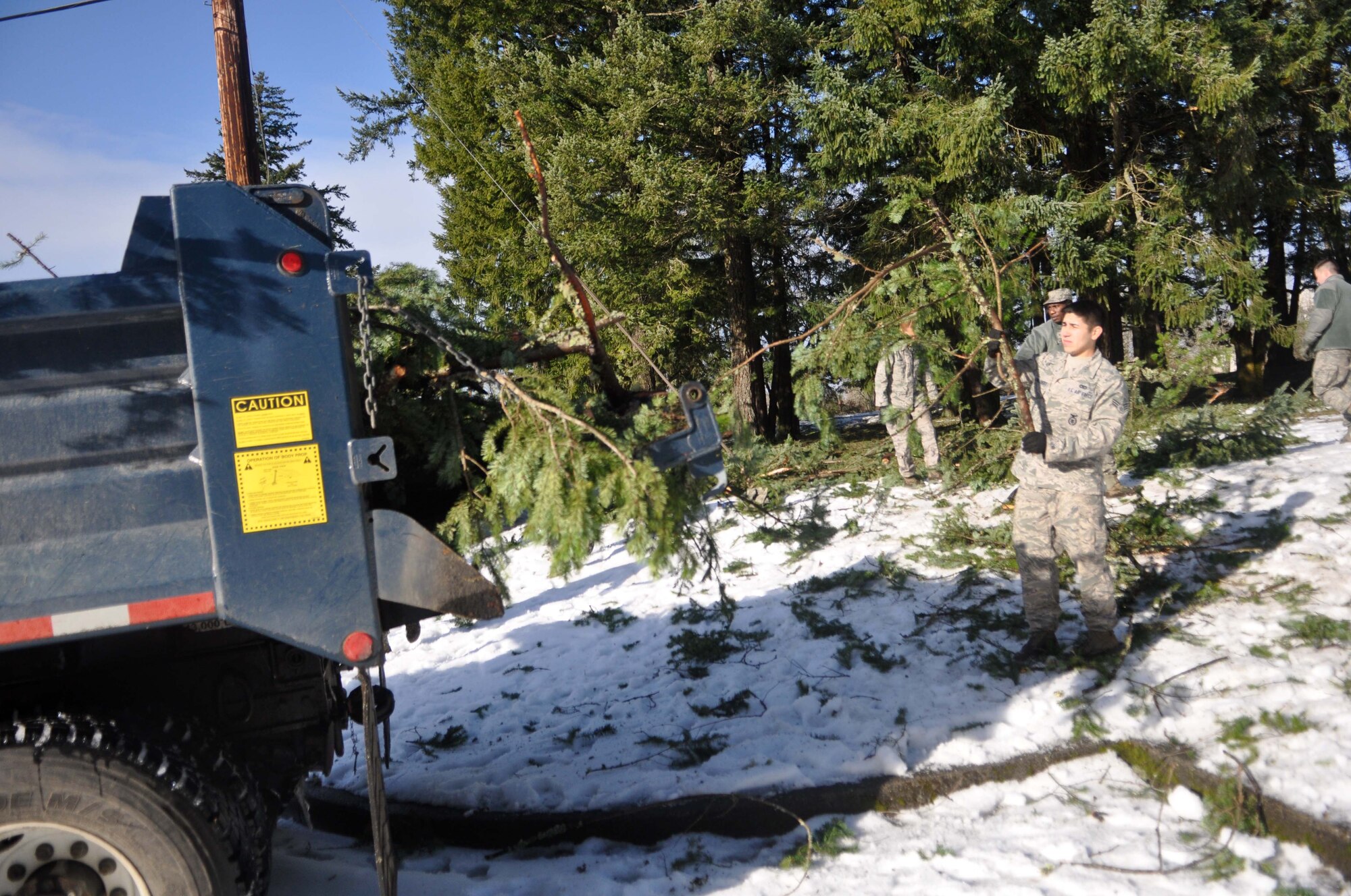 Airmen assigned to the 627th Civil Engineer Squadron clear debris following a winter storm Jan. 23, 2012, at Joint Base Lewis-McChord, Wash. McChord Field experienced a winter storm which accumulated more than nine inches of snow and caused massive power outages across the installation. (U.S. Air Force photo/Airman 1st Class Leah Young)