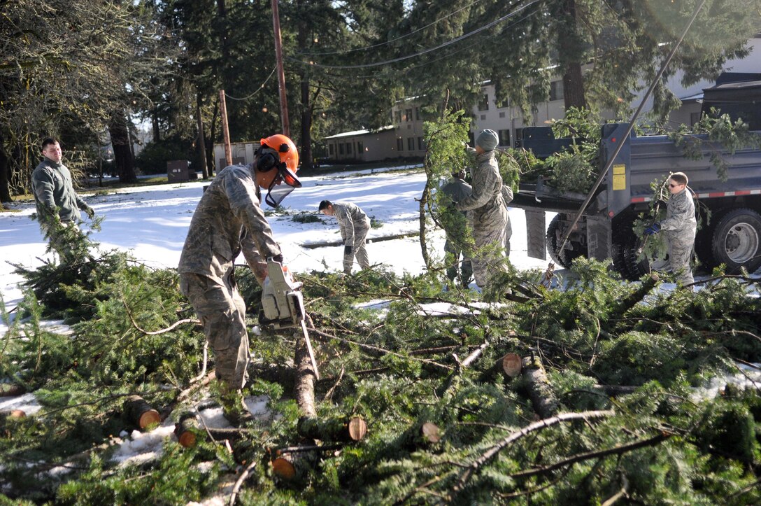 Airmen assigned to the 627th Civil Engineer Squadron clear debris following a winter storm which caused massive damage to the installation from ice and falling tree limbs Jan. 23, 2012, at Joint Base Lewis-McChord, Wash. The storm accumulated more than nine inches of snow and caused massive power outages across the installation. (U.S. Air Force photo/Airman 1st Class Leah Young)
